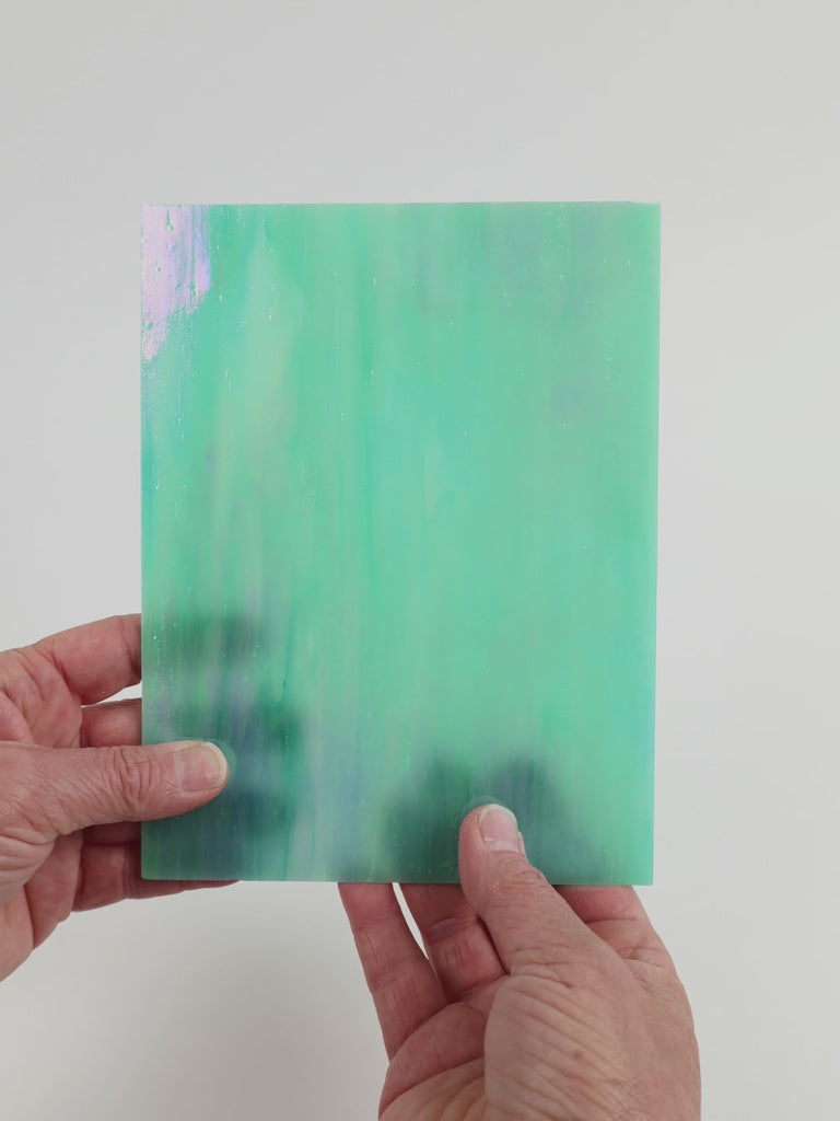 Video of the Aquamarine Pearl glass plate in iridescent translucent blue, 15x19cm, held up and tilted to show its pattern and transparency