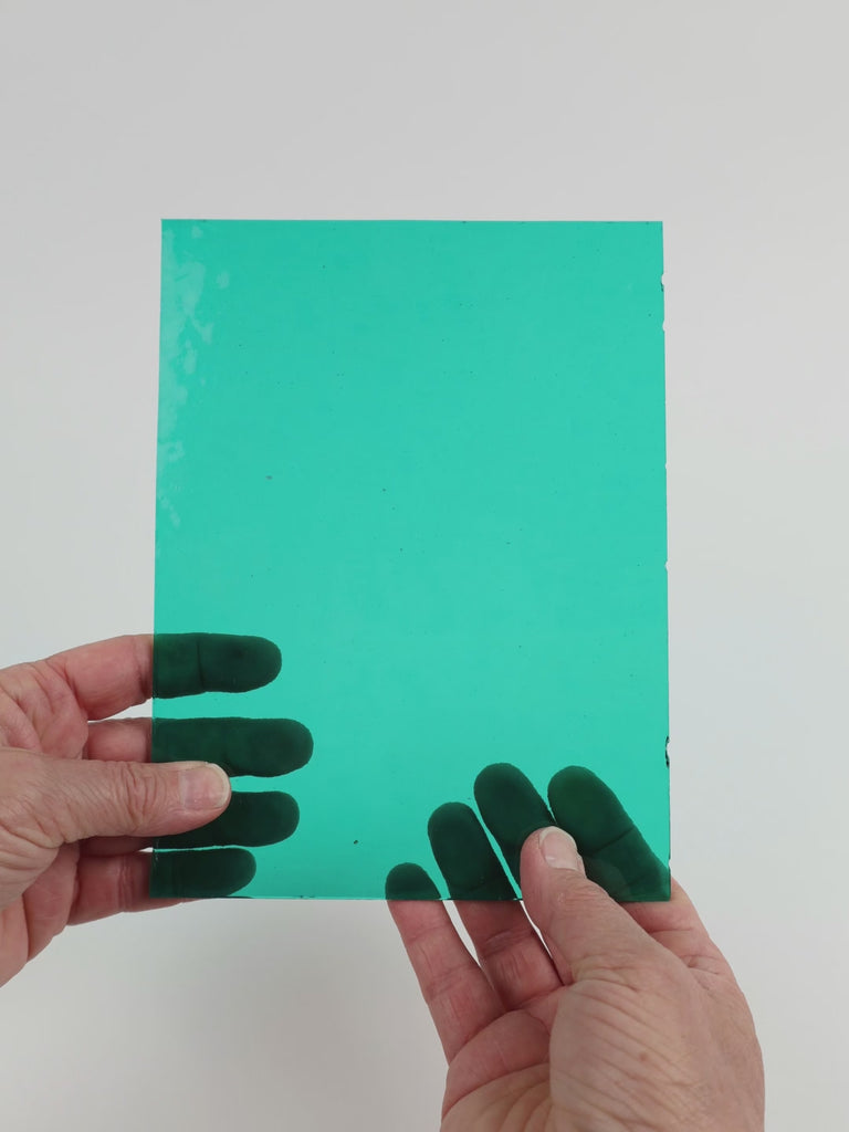 Video of the Teal glass plate in transparent teal, 15x19cm, held up and tilted to show its pattern and transparency