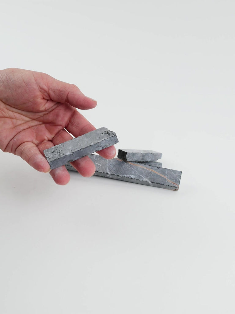 Video of Marble Bars XL Nero Marquina in opaque black natural marble, 1–20 cm long and 8 mm thick, picked up by hand and turned to show their length, colour and natural veining