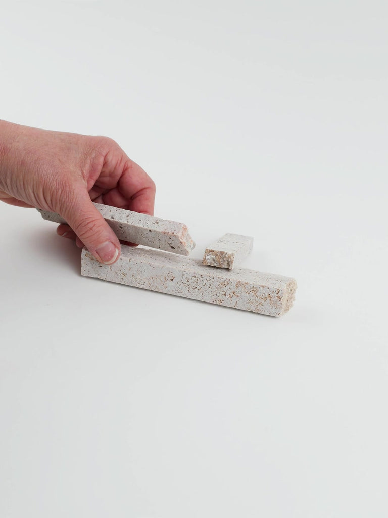 Video of Marble Bars XL Travertine Noce in opaque camel-brown natural travertine, 1–20 cm long and 8 mm thick, picked up by hand and turned to show their length, colour and porous texture