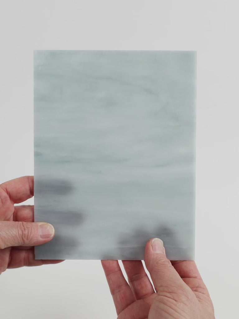 Video of the grey smoke glass plate in grey translucent marbled, 15x19cm, held up and tilted to show its pattern and transparency