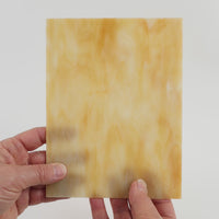 Video of the creme caramel glass plate in cmel translucent, 15x19cm, held up and tilted to show its pattern and transparency