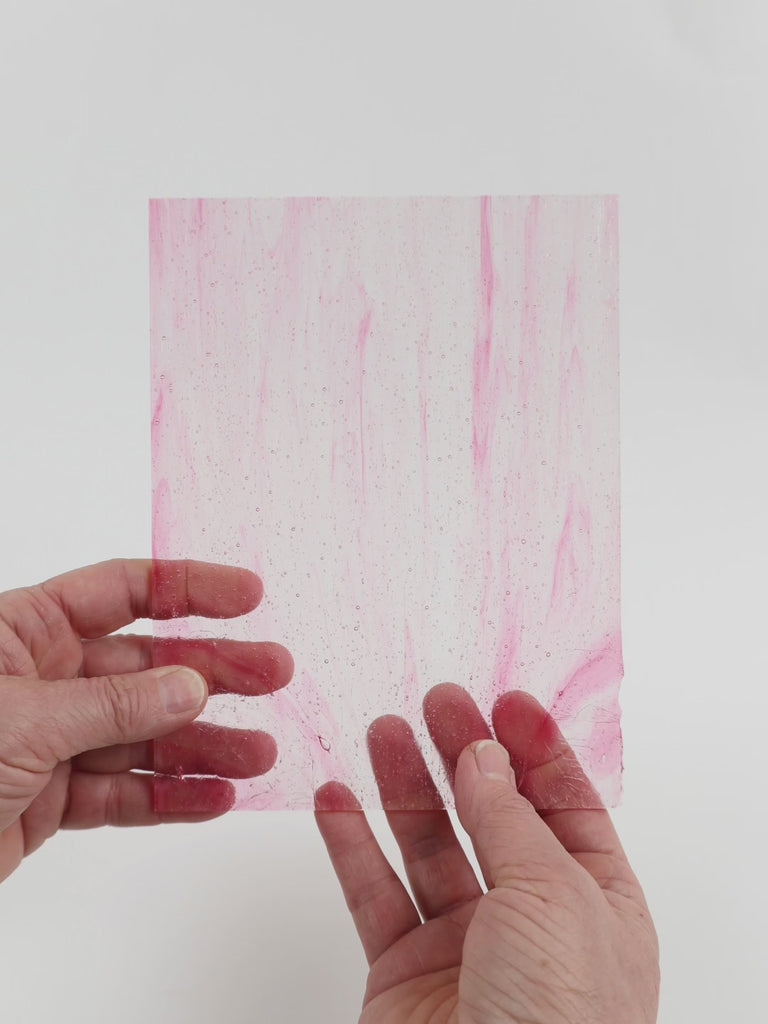 Video of the Fuchsia Wispy glass plate in transparent pink, 15x19cm, held up and tilted to show its pattern and transparency